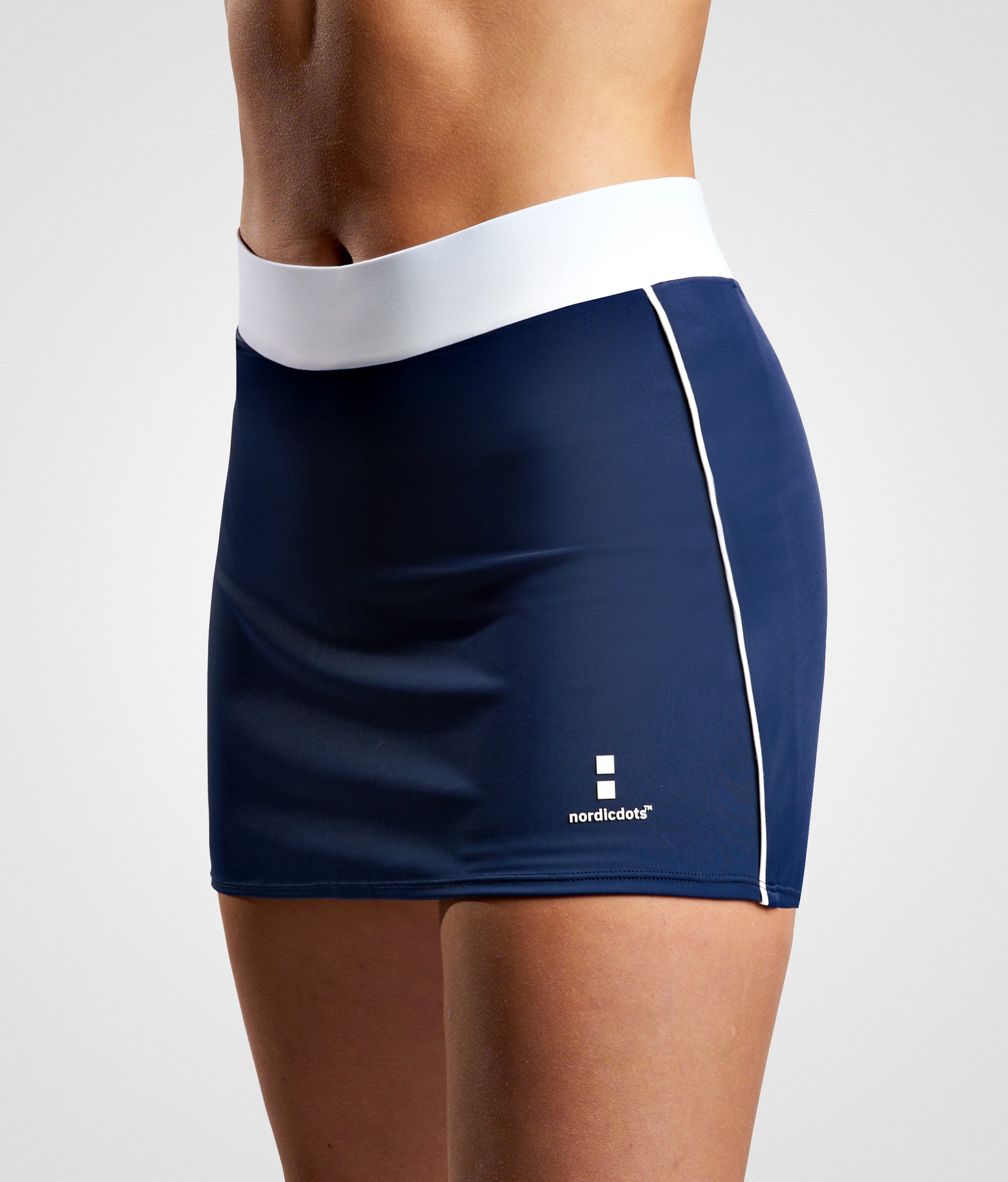 nordicdots performance skirt for padel, tennis or golf with flat elastic waistband and built-in compression shorts.